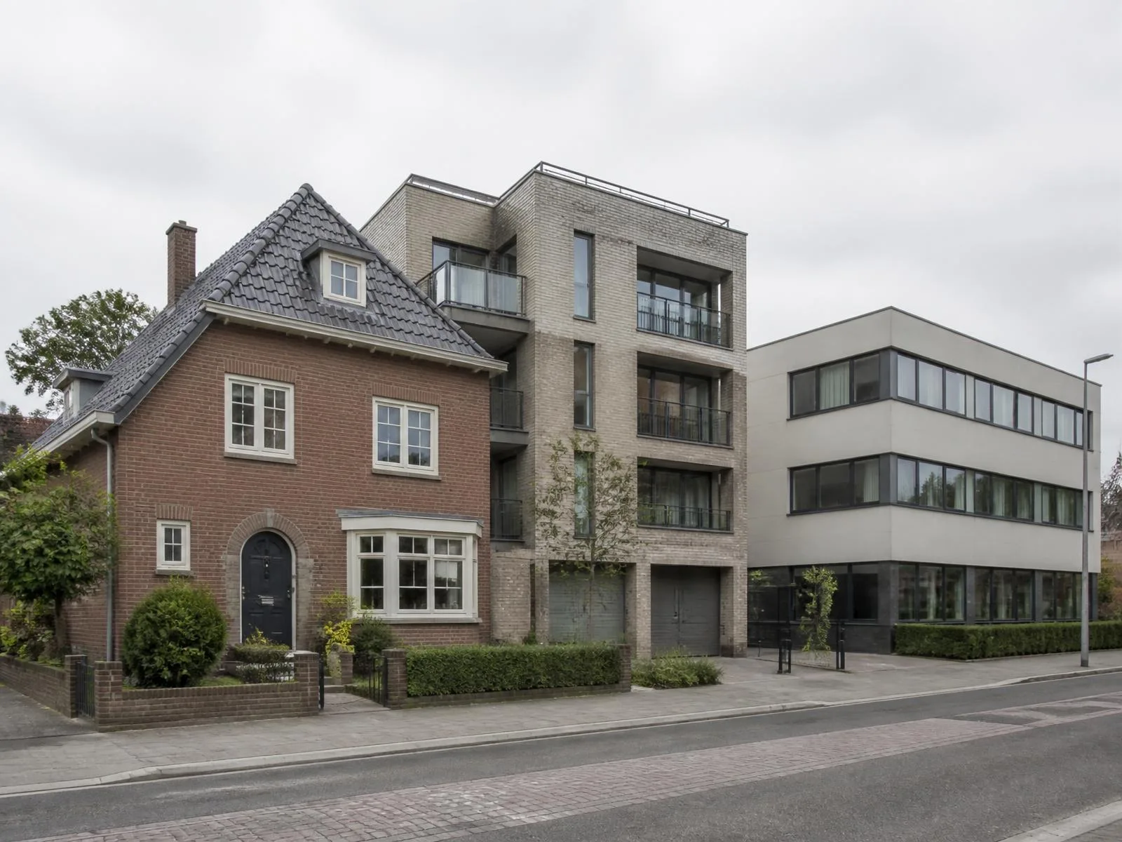 Rijwoning, appartementsgebouw en kantoorgebouw naast elkaar in een straatbeeld