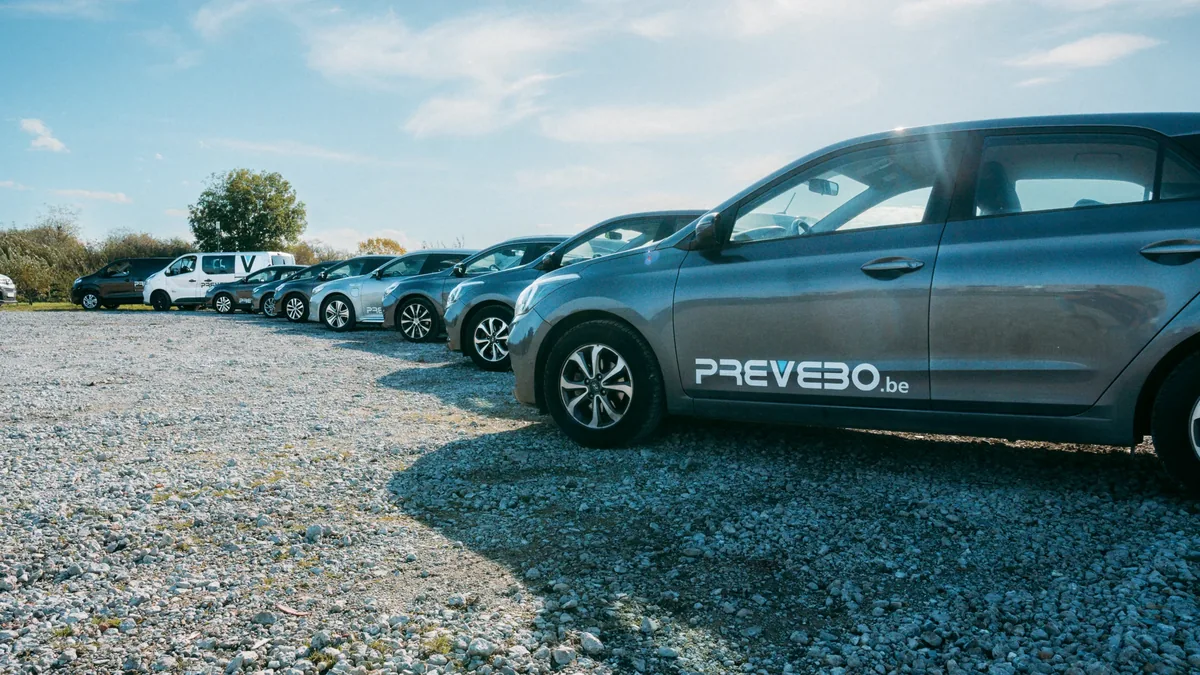 Wagenpark van Prevebo: een rij bedrijfswagens met PREVEBO.be-belettering op een verharde parking